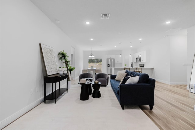 living room with light wood-type flooring and sink