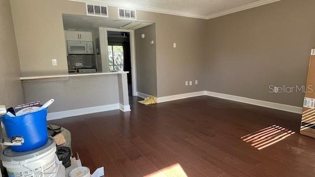 interior space with dark wood-type flooring and ornamental molding