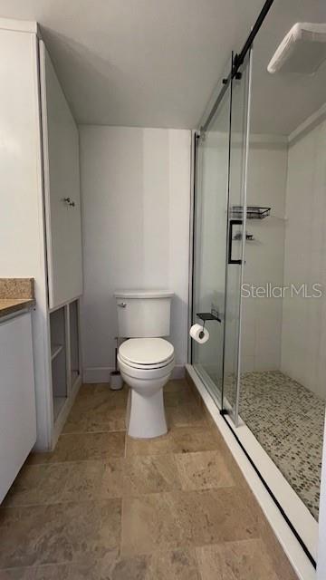 bathroom with vanity, an enclosed shower, and toilet