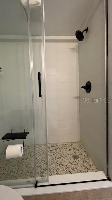 bathroom featuring toilet and a shower with shower door