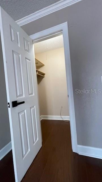 hallway with dark wood-type flooring and a textured ceiling