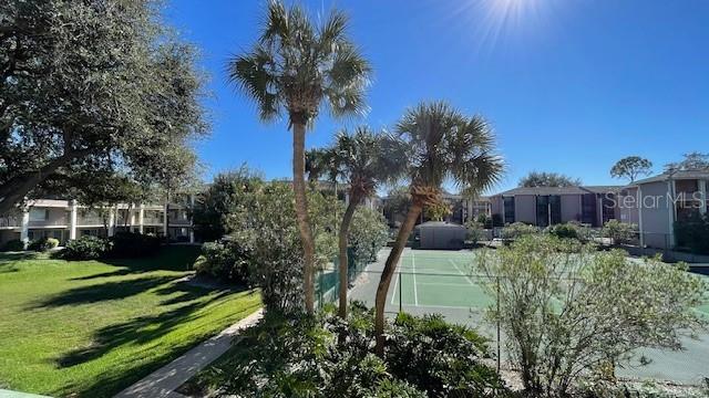 view of tennis court featuring a lawn