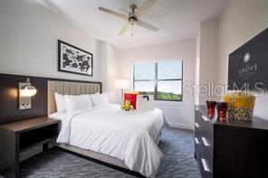 bedroom with ceiling fan and dark colored carpet