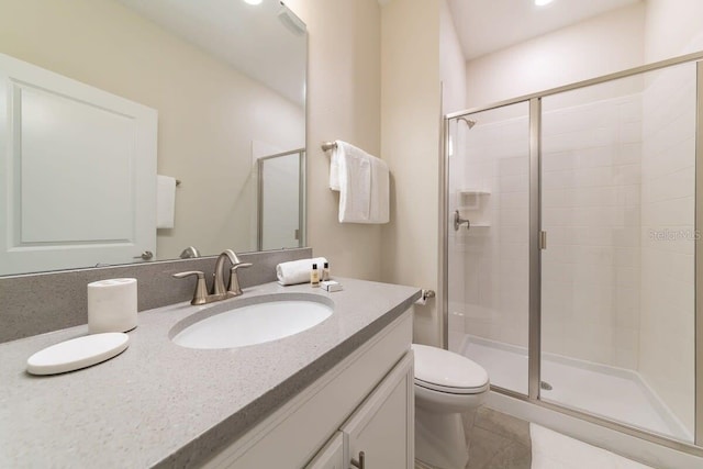 bathroom with tile patterned floors, vanity, toilet, and an enclosed shower