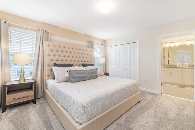 carpeted bedroom featuring ensuite bath and a closet