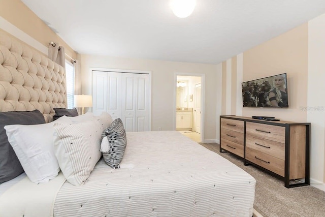 carpeted bedroom featuring ensuite bathroom and a closet