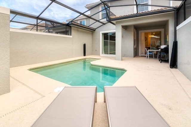 view of swimming pool with glass enclosure and a patio