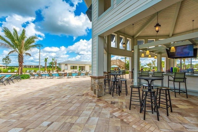 view of patio / terrace featuring a community pool and a bar