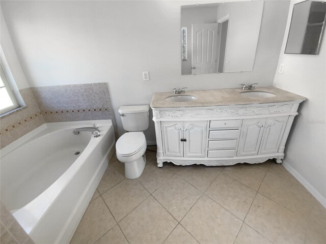 bathroom featuring tile patterned floors, vanity, toilet, and a tub to relax in