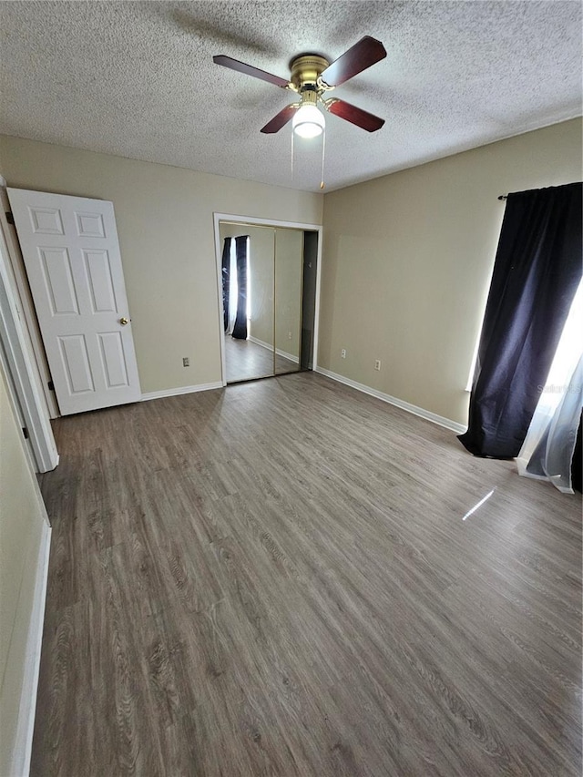 unfurnished bedroom featuring wood-type flooring, a textured ceiling, and a closet