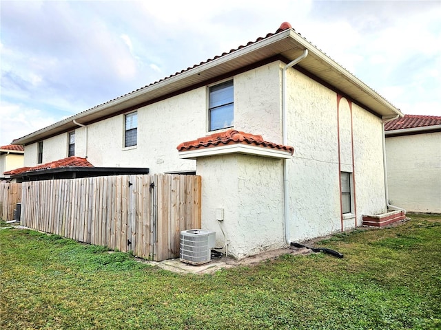 view of home's exterior featuring cooling unit and a yard