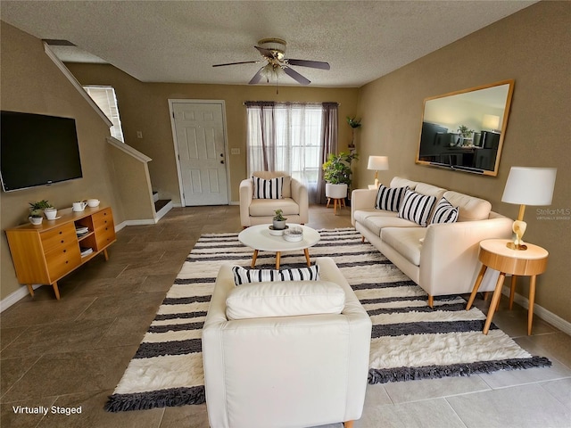 living room with ceiling fan and a textured ceiling