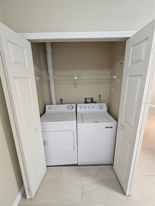 laundry room featuring washing machine and dryer and light tile patterned flooring