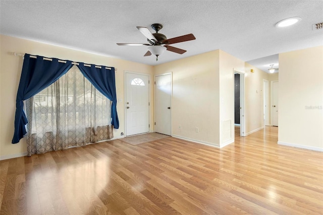 interior space featuring ceiling fan, light hardwood / wood-style floors, and a textured ceiling