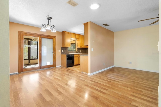 kitchen featuring backsplash, decorative light fixtures, a textured ceiling, and light hardwood / wood-style flooring