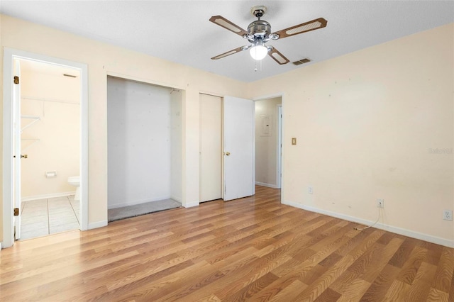 unfurnished bedroom with ceiling fan, ensuite bath, and light hardwood / wood-style flooring