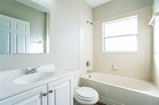 full bathroom featuring vanity, tiled shower / bath combo, and toilet