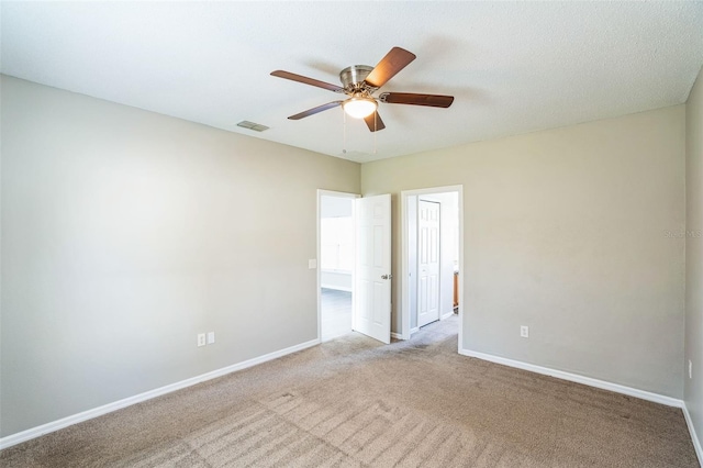 unfurnished room featuring light carpet, a textured ceiling, and ceiling fan