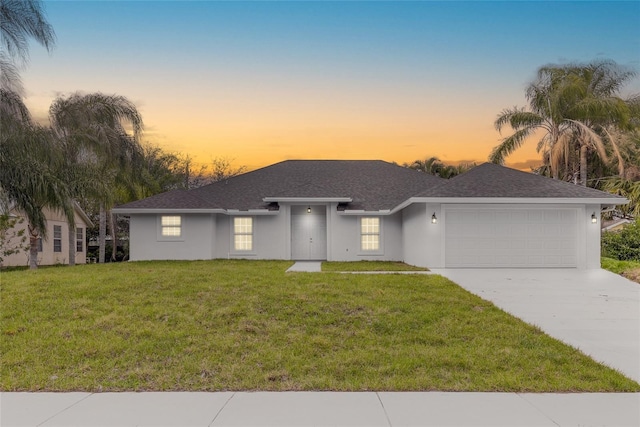 ranch-style house with a garage and a lawn