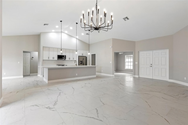 unfurnished living room featuring ceiling fan with notable chandelier and high vaulted ceiling