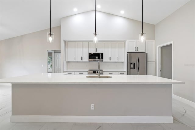 kitchen with decorative light fixtures, stainless steel appliances, and a large island with sink