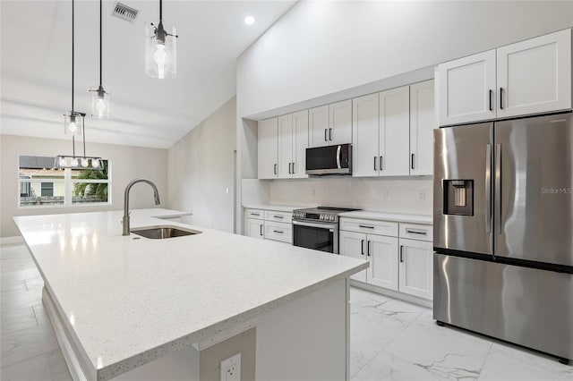 kitchen featuring sink, stainless steel appliances, an island with sink, pendant lighting, and white cabinets