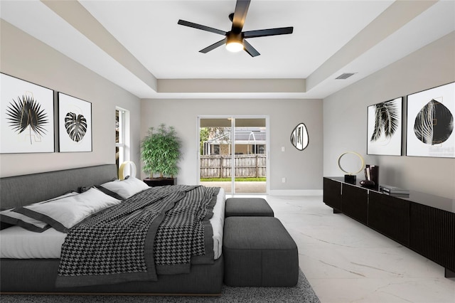 bedroom with a raised ceiling, ceiling fan, and access to outside