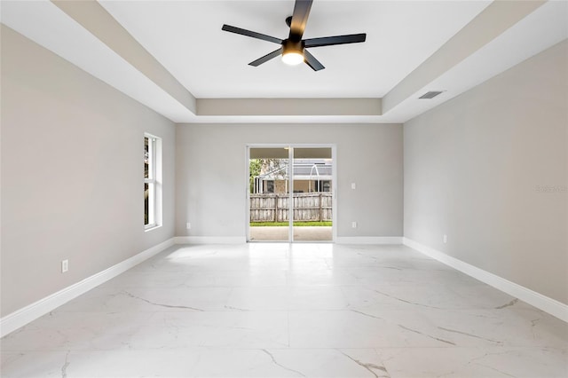 unfurnished room with a tray ceiling and ceiling fan