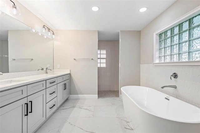 bathroom featuring vanity and independent shower and bath