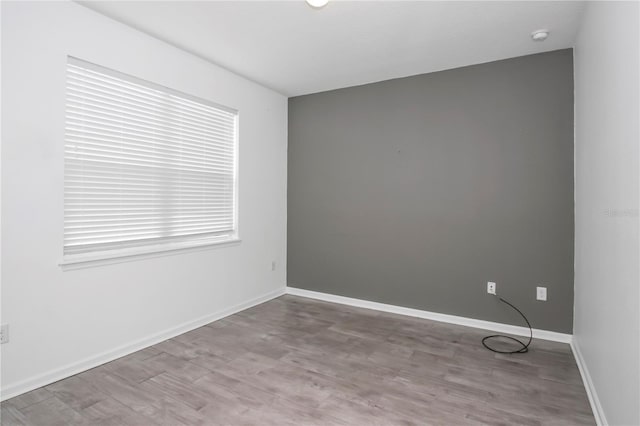 unfurnished room featuring light hardwood / wood-style floors and a wealth of natural light