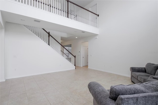 living room featuring light tile patterned floors and a towering ceiling