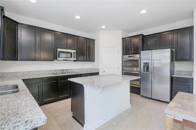 kitchen featuring a kitchen island, appliances with stainless steel finishes, dark brown cabinets, light tile patterned flooring, and light stone counters