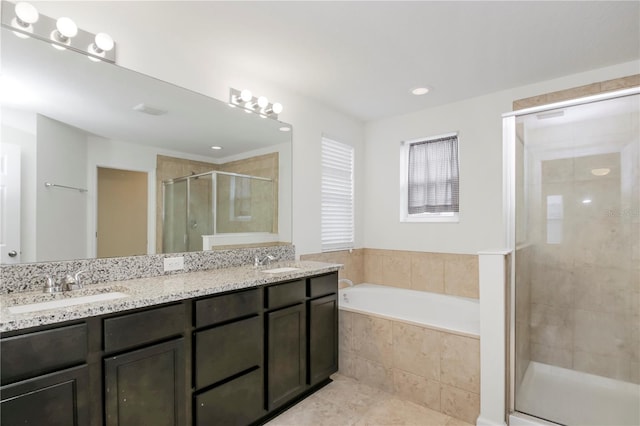 bathroom with tile patterned floors, vanity, and shower with separate bathtub