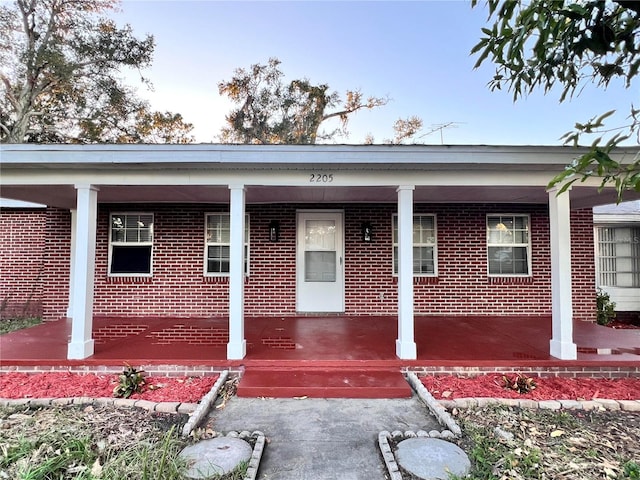 view of exterior entry with covered porch