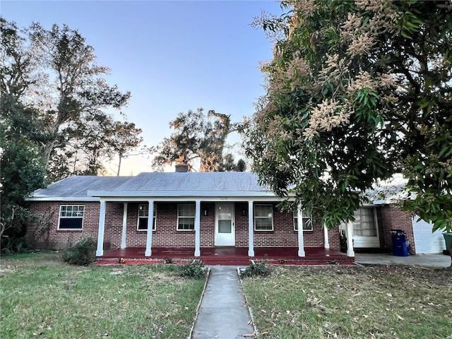 ranch-style home featuring a yard and a porch