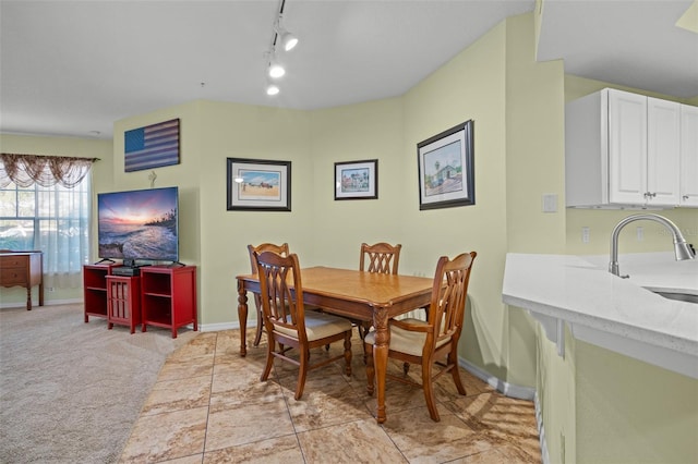 carpeted dining space featuring track lighting and sink