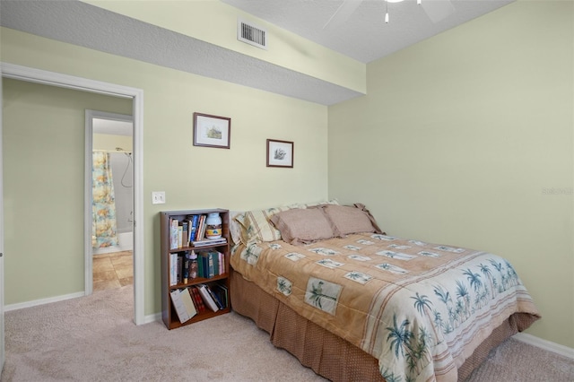 bedroom featuring light carpet, a textured ceiling, and ceiling fan