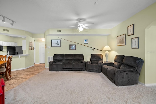 carpeted living room featuring ceiling fan and rail lighting