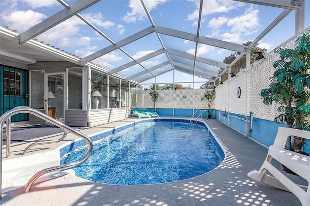 view of swimming pool featuring a patio area and a lanai