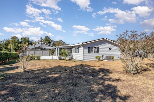 rear view of house with a lanai and central air condition unit