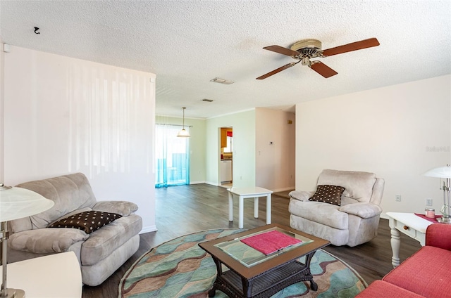 living room with dark hardwood / wood-style floors, ceiling fan, and a textured ceiling