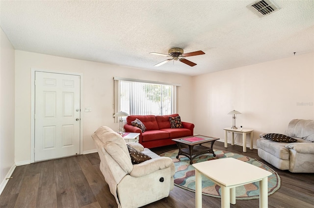 living room with ceiling fan, dark wood-type flooring, and a textured ceiling