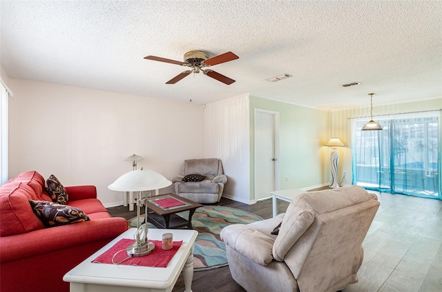 living room featuring ceiling fan, wood-type flooring, and a textured ceiling