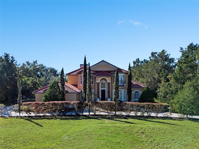 mediterranean / spanish home with a front yard