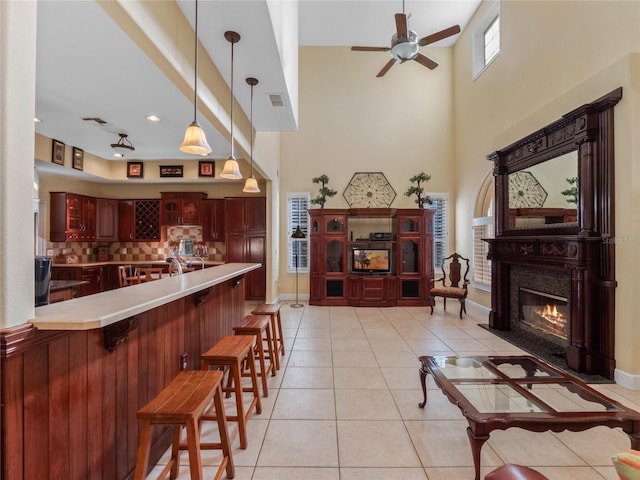 tiled living room featuring a towering ceiling and ceiling fan