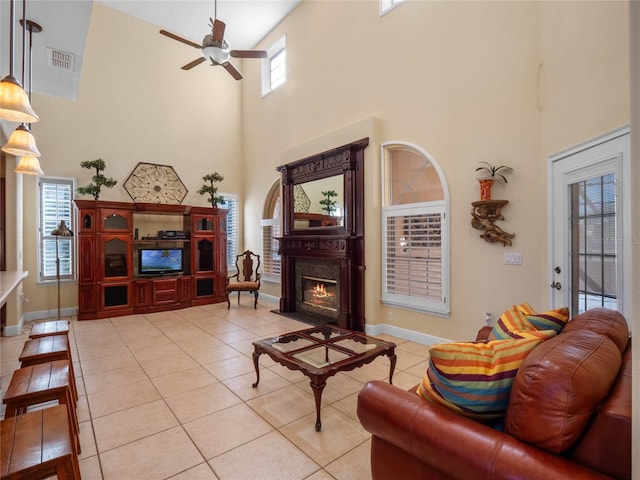 living room with plenty of natural light, light tile patterned floors, and a high ceiling