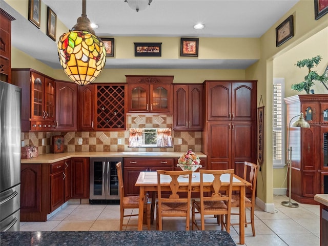 kitchen featuring stainless steel refrigerator, wine cooler, light tile patterned floors, and decorative light fixtures