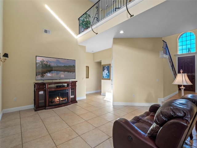 living room featuring a towering ceiling and light tile patterned flooring