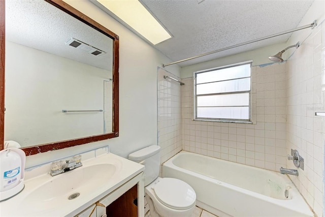 full bathroom featuring vanity, a textured ceiling, toilet, and tiled shower / bath