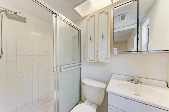 bathroom with vanity, a shower with shower door, a textured ceiling, and toilet